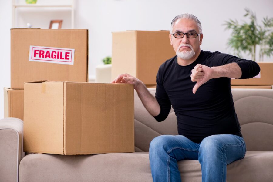 Man sitting by the box showing thumb-down