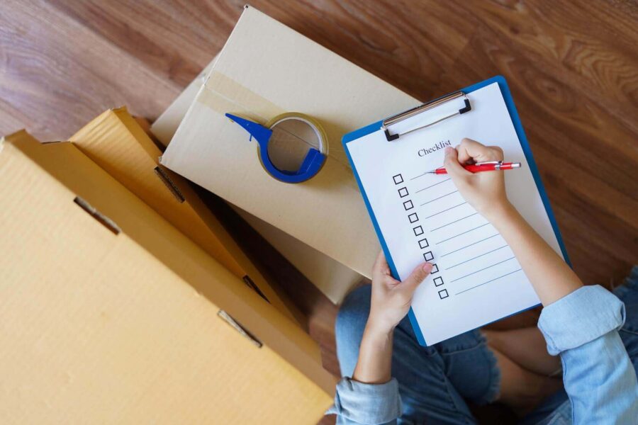 A person making a checklist before cross-country moving