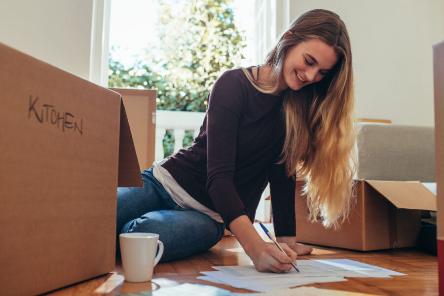 Woman making a checklist before long-distance moving