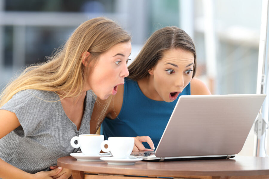 Two surprised girls looking at a laptop