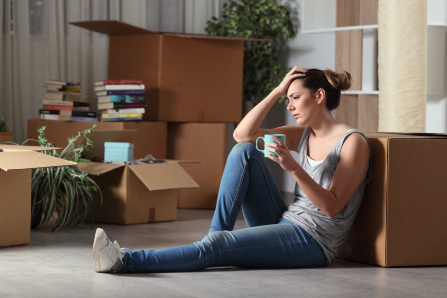 A stressed-out woman sitting on the floor with boxes