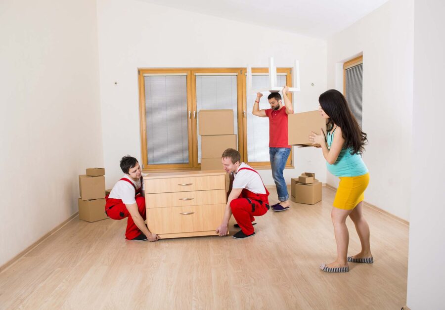 A couple and professional movers clearing the room
