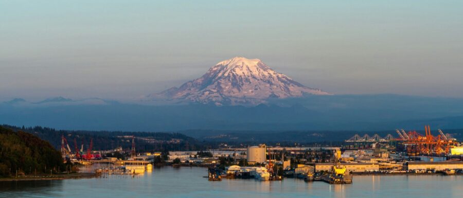 White and brown buildings in the city of Tacoma with Mount Rainier in the background.